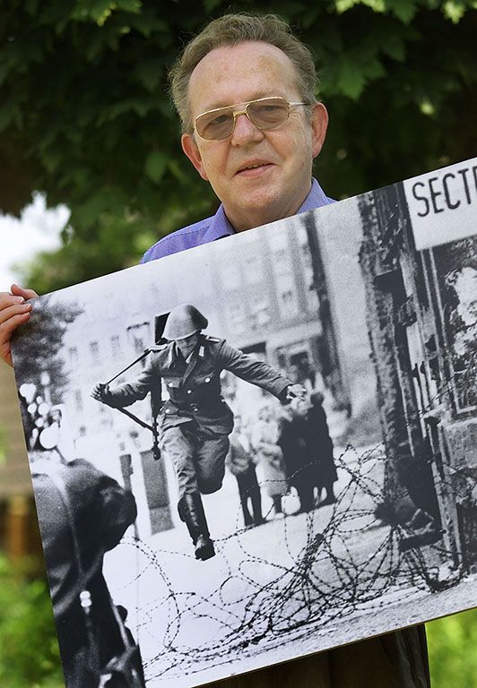 פיטר לייבינג המבוגר מחזיק את התמונה שהכניסה אותו להיסטוריה